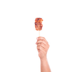 Hand holding grilled pork in bamboo stick isolate on white