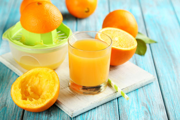 Obraz na płótnie Canvas Citrus fruits with juicer on a blue wooden table