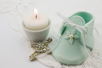 Obraz na płótnie Canvas Photo of turquoise fondant baby boot with pearl,crystal cross an
