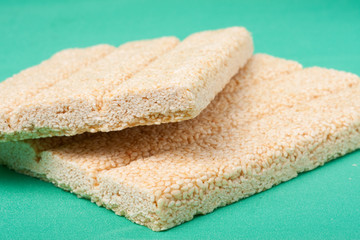 Honey bars with sesame seeds on green background