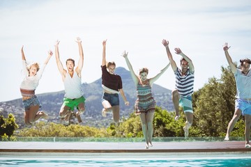 Group of friends jumping in swimming pool