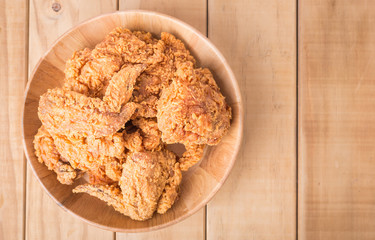 Top view fried chicken in wooden plate on wooden plank