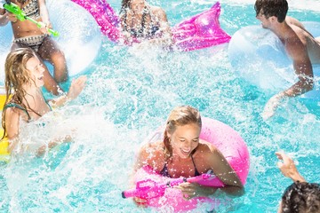 Happy friends enjoying in the swimming pool
