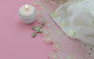 Vintage christening baby dress on pink background with cross and