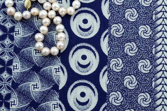 Overhead close up of pearl necklace on indigo cloth