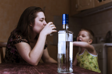 Woman with alcoholic drink and her child