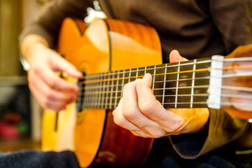 Fototapeta na wymiar the young guy playing an acoustic guitar. Shooting backlit