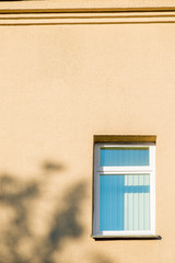 yellow wall and a window with shutters