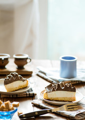 slices of cake with a cream with tea set on a served table