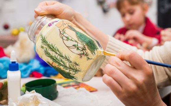 decoupage bottle. Professional painter paints a souvenir