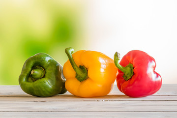 Pepper on a row on a wooden table