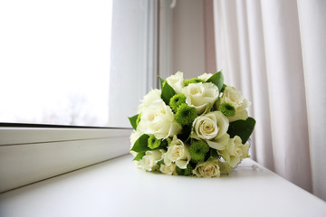 Beautiful bridal bouquet of flowers on the windowsill