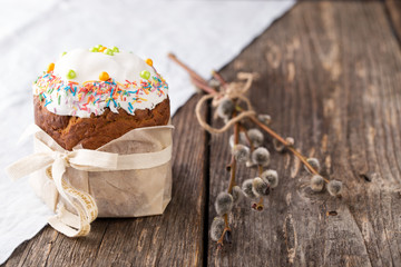 Traditional russian easter cake Kulich with willow branch on wooden background