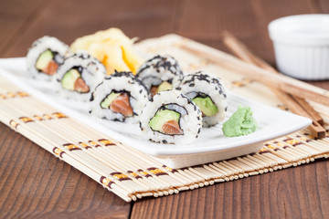 Uramaki sushi with avocado, raw salmon and black sesame