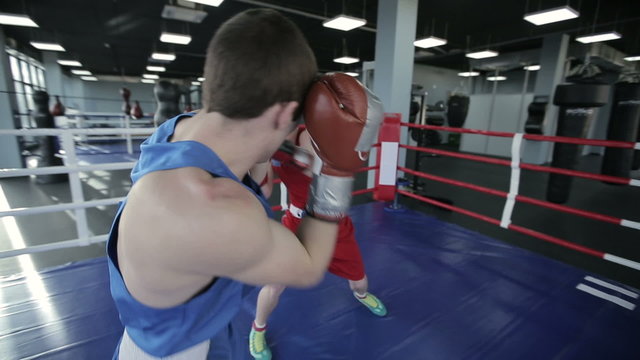 Two young professional boxers are fighting on the boxing ring