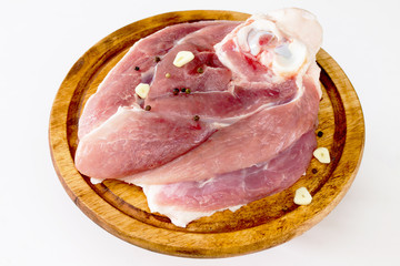 Piece raw meat on a wooden board with garlic and pepper