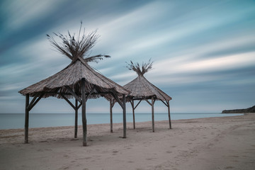 Fototapeta na wymiar Wooden shelters on the beach
