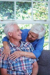 Happy wife embracing while looking at senior man