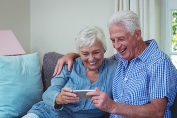 Happy senior couple using phone  - obrazy, fototapety, plakaty