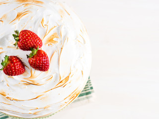 Sponge cake with Swiss meringue on white and gray pastel wooden background