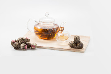 exotic green tea with flowers in glass teapot and cup isolated on studio background