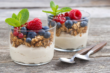 dessert with milk cream, muesli and berries in glasses