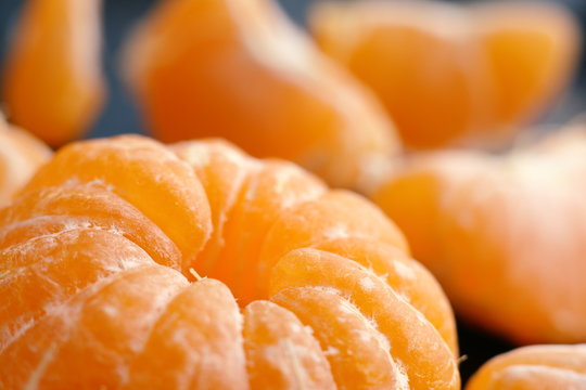 Cantels of mandarins with peels on a dark table. Macro