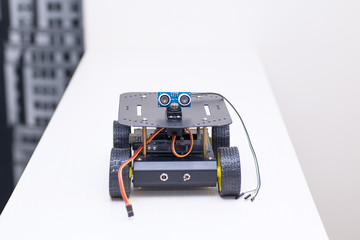metal robot on wheels is on the table