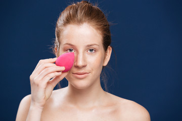 Woman applying makeup with sponge