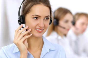 Call center. Focus on beautiful woman in headset