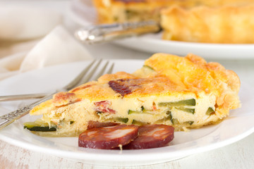 tart with smoked sausages on white wooden background