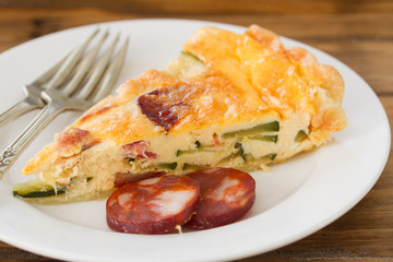 tart with smoked sausages on brown wooden background