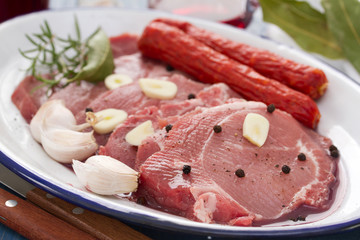 pork with black pepper, smoked sausages and garlic on white dish