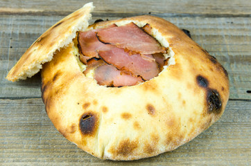 Baked flat bread stuffed with prosciutto and cream cheese