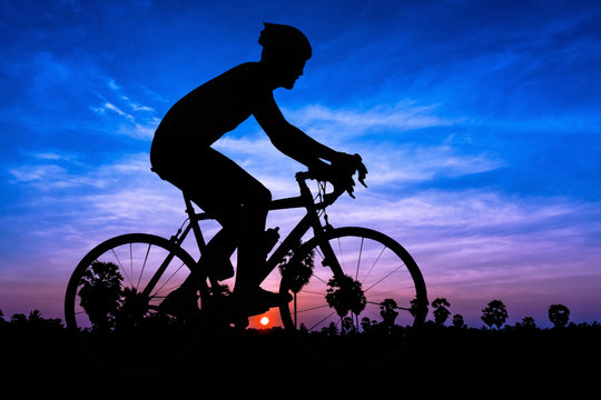 Man silhouette cycling on twilight time