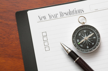 Concept : pen on book with checklist box with wood background - New Year Resolutions