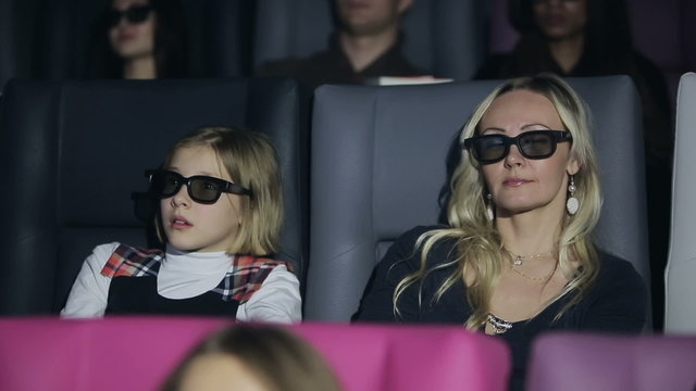 Mother and daughter is watching film in a 3d cinema