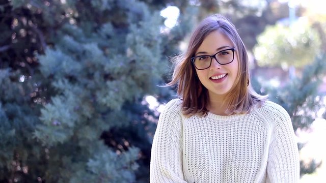 Joven rubia sonriendo en el parque