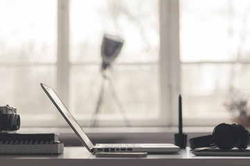 Inspirating workspace. Designer's desk with laptop. Fashionable. Sunlight from the window.