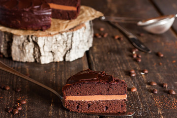piece of chocolate cake on a dark wooden background