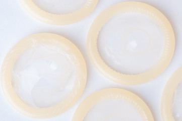 Rolled latex condom on white background