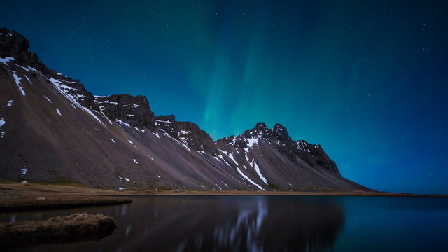Northern Lights above a mountain and lake