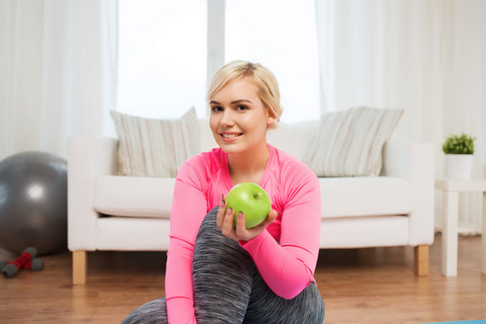 happy woman eating green apple at home