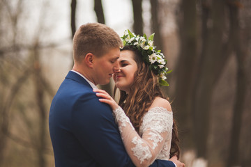 Happy wedding couple, bride and groom walking in the autumn forest, park