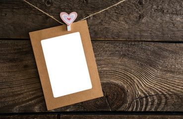 Paper photo frame on the background of wooden wall in the old style