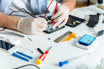 Electrician checks electronic hardware with a multimeter