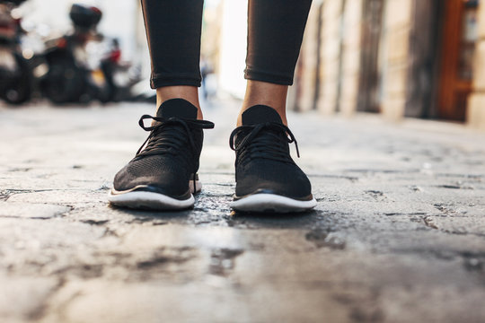Black sneakers of sportive young woman, close-up