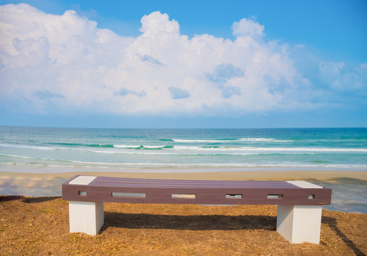 The bench on tropical beach behind beatiful sea with couldy at v