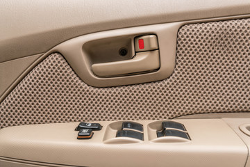Car interior details ; door handle with windows controls - close up