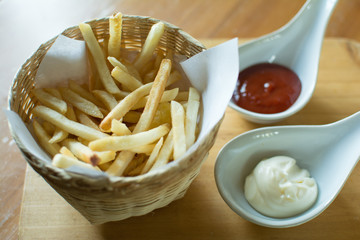 Tasty french fries on cutting board, on wooden table background.